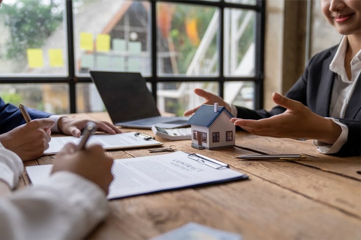 Home sales and home insurance concept. Real estate agent talked about the terms of the home purchase agreement and asked the customer to sign the documents to make the contract legally.