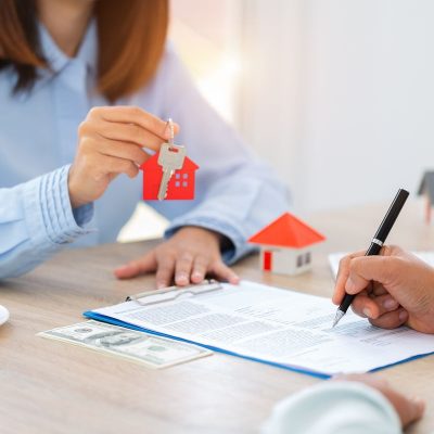 Home sales and home insurance concept. Real estate agent talked about the terms of the home purchase agreement and asked the customer to sign the documents to make the contract legally.